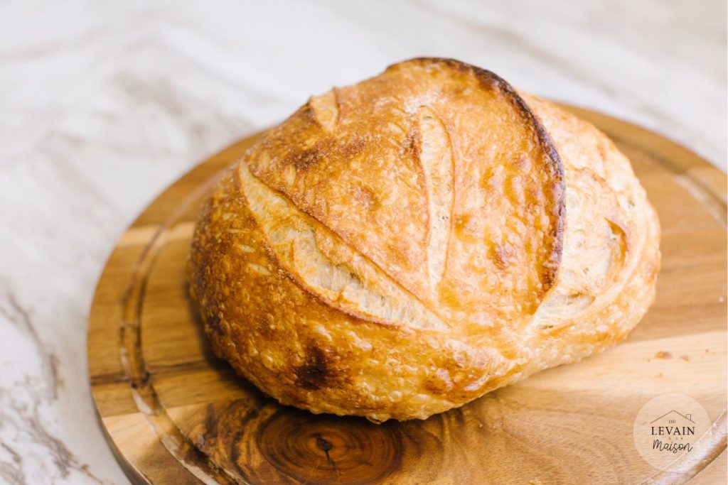 Pain au blé complet et farine de pain sur une planche en bois